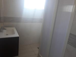 a white bathroom with a sink and a window at Maison vintage Rabat Agdal in Rabat