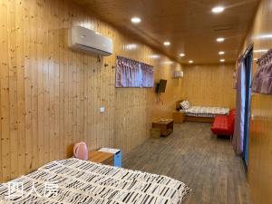 a hospital room with two beds and a tv at Zhenan Pink Panther in Linbian