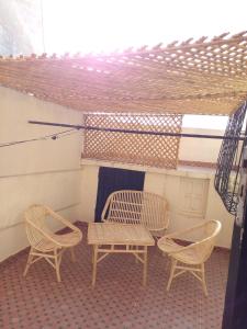 un patio con 2 sillas, una mesa y una mesa con sillas en Maison vintage Rabat Agdal, en Rabat