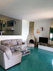 a living room with a couch and a fireplace at Villa Buonasera in Santa Flavia