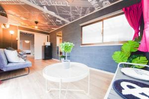 een woonkamer met een tafel en een bank bij Sanacion Namba 難波千日前の5LDK120平米 駅徒歩2分 広々バルコニーでバーベキューも可能 in Osaka
