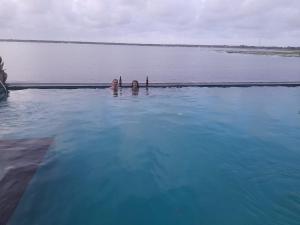 two people swimming in a large body of water at Oruwa Boutique Villas in Arugam Bay