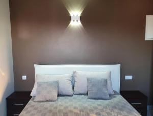 a bed with two pillows and a light above it at Apartments Villa Ines Skofije -near Koper in Zgornje Škofije