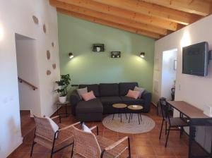 a living room with a couch and a table and chairs at Casa do Bairro - A Gema escondida da Santa Catarina da Fonte do Bispo in Santa Catarina da Fonte do Bispo