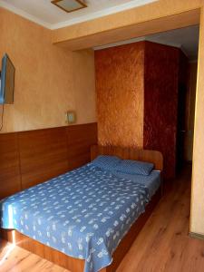 a bedroom with a bed with a blue comforter at Rodina Hotel in Odesa