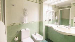 a bathroom with a white toilet and a sink at Hotel Villa Zoia in Boltiere