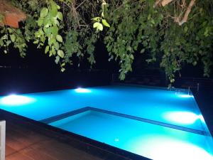 a swimming pool lit up at night with lights at Oruwa Boutique Villas in Arugam Bay