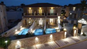 an image of a house with a swimming pool at night at Sarantis Hotel in Hanioti