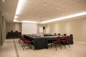 a conference room with a long table and red chairs at Splendido Bay Luxury Spa Resort in Padenghe sul Garda +77 photos