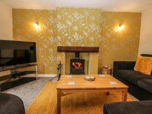 a living room with a couch and a fireplace at 1 Springfort Cottages in Penrith