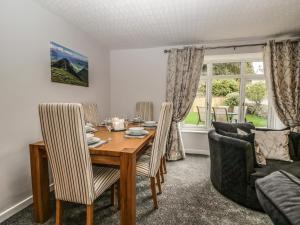 a dining room with a wooden table and chairs at 1 Springfort Cottages in Penrith