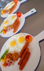 two plates of food with eggs and carrots on a table at Oruwa Boutique Villas in Arugam Bay