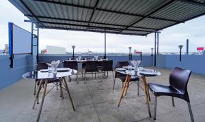 a restaurant with tables and chairs on a roof at Treebo Trend Surya Comforts 200 Mtrs From Kolhapur Railway Station in Kolhapur
