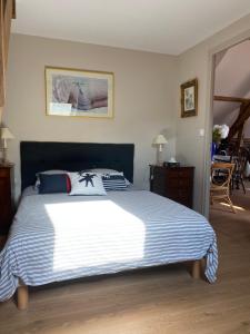 um quarto com uma cama grande e um cobertor azul e branco em La Grange aux portes du Touquet, 1 ou 2 ch, terrasse, jardin, parking em Cucq