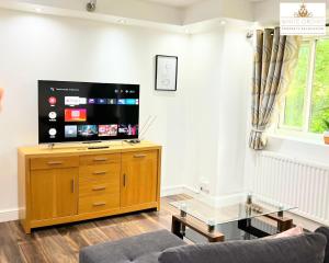 a living room with a flat screen tv on a wooden cabinet at 2 Bed Apartment in Stevenage SG1 Hertfordshire By White Orchid Property Relocation Leisure & Business in Stevenage