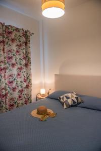 a bedroom with a bed with a hat on it at Boboli Holiday House Acharavi Corfu in Acharavi