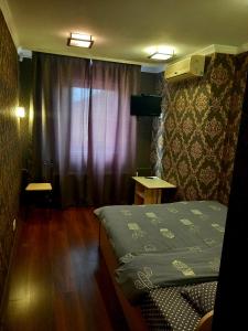 オデッサにあるRodina Hotelのベッドと窓が備わる小さな客室です。