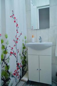a bathroom with a sink and a tree in it at Vila Norina in Oeşti-Pămînteni +39 photos