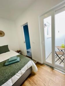 a bedroom with a bed and a sliding glass door at Casa da Mostardeira in Évora +33 photos
