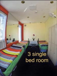 Habitación con 3 camas y palabras de habitación individual. en lilihostel en Melbourne