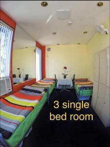 a room with three beds in it with the words single bed room at lilihostel in Melbourne