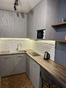 a small kitchen with a sink and a microwave at Florent's Superb Studio, free parking & garden!! in Tirana