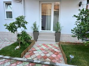 - une terrasse couverte à l'avant d'une maison avec une porte dans l'établissement Florent's Superb Studio, free parking & garden!!, à Tirana