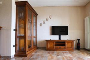 uma sala de estar com uma televisão e um armário em Appartamento con terrazzo a Capodimonte by Wonderful Italy em Nápoles