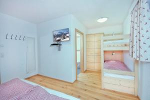 een slaapkamer met een stapelbed en houten vloeren bij Grünerstein Chalet Jungbrunnen in Bramberg am Wildkogel