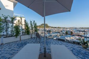 a patio with an umbrella and a view of a marina at Baia Flegrea Meublè in Bacoli