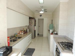 a kitchen with white cabinets and a stove top oven at Ipanema Copa Hostel in Rio de Janeiro