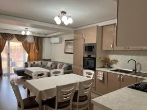 een keuken en een woonkamer met een tafel en een bank bij Guest House Tatiana /Къща за гости ТАТЯНА in Petrich