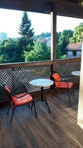 two tables and chairs on a balcony with a view of trees at Apartment and rooms"Tabašnice"Tuzla centar in Tuzla