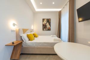 a bedroom with a bed with yellow pillows at Baia Flegrea Meublè in Bacoli