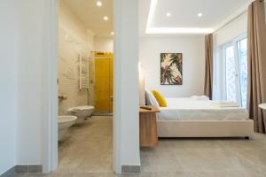 a bedroom with a bed and a bathroom with a toilet at Baia Flegrea Meublè in Bacoli