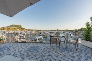 a balcony with two chairs and a view of a marina at Baia Flegrea Meublè in Bacoli
