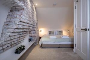 a bedroom with a bed and a brick wall at Nutshell Cottage in Lymington