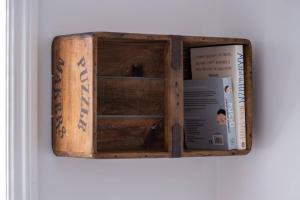 a wooden box with a book on a wall at Nutshell Cottage in Lymington