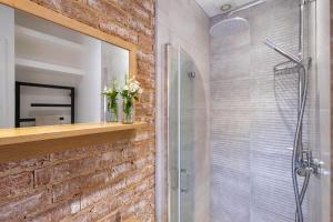 a bathroom with a glass shower with a brick wall at Nutshell Cottage in Lymington +27 photos
