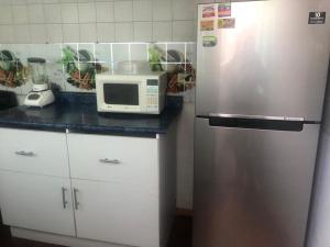 a kitchen with a stainless steel refrigerator and a microwave at Espacios de Pando in Puebla