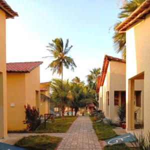 a walkway between two buildings with palm trees at Pousada e Chalés Recantos do Mar in Barra Grande
