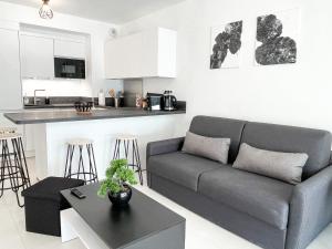 ein Wohnzimmer mit einem Sofa und einem Tisch in der Unterkunft T2 NEUF TERRASSE PRES des PLAGES in Saint-Cyr-sur-Mer