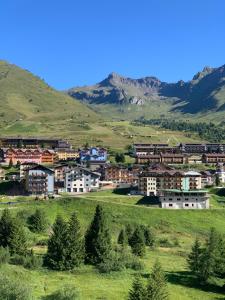 a town on a hill with mountains in the background at Casa Porrone in Passo del Tonale