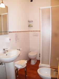 a white bathroom with a toilet and a sink at Albergo Amici in Varese Ligure