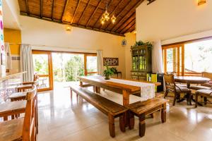 uma sala de jantar com uma mesa e bancos de madeira em Recanto Namastê - Hospedagem em Cunha