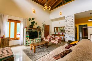 a living room with a couch and a tv at Recanto Namastê - Hospedagem in Cunha