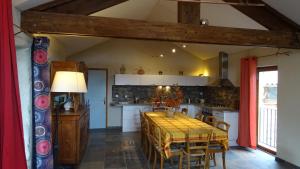 a kitchen with a table with a yellow table cloth at Gîte de Chapelèche Les Glycines in Gluiras