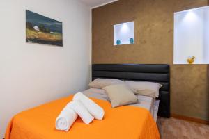 a bedroom with an orange bed with towels on it at Villa Ina in Cinisi +21 photos