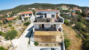 a house on a hill with a car parked in front at Villa Accordo in Vinišće