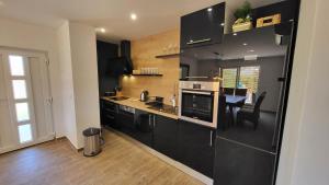 a kitchen with black cabinets and a dining room at Villa Accordo in Vinišće